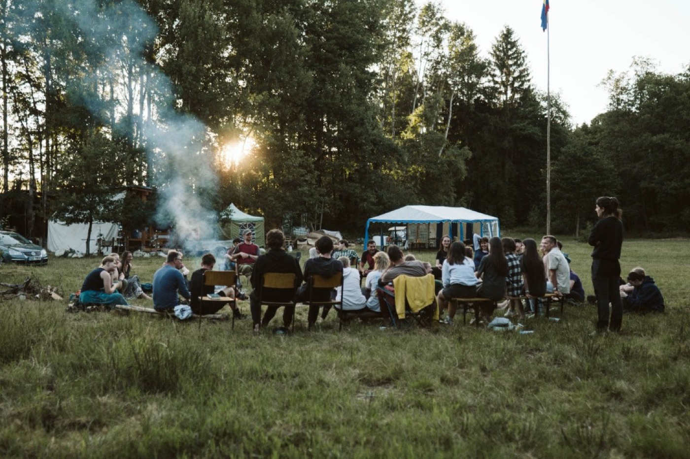A group gathered outside around a campfire