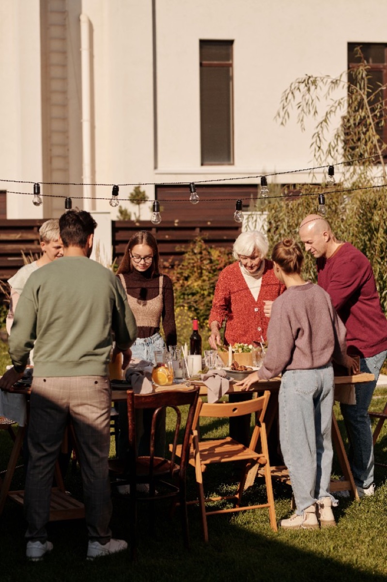 Friends gathering around an outdoor dinner table